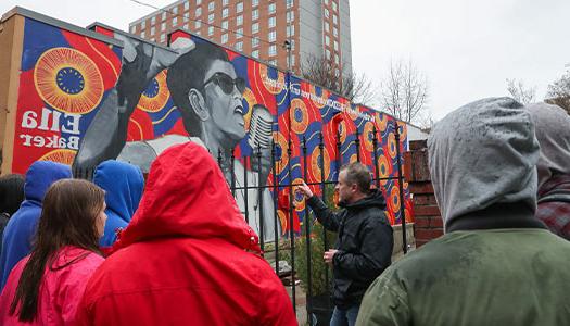 students and instructors view a mural on their visit to atlanta